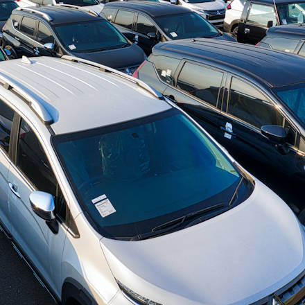 Several cars parked next to each other in several rows